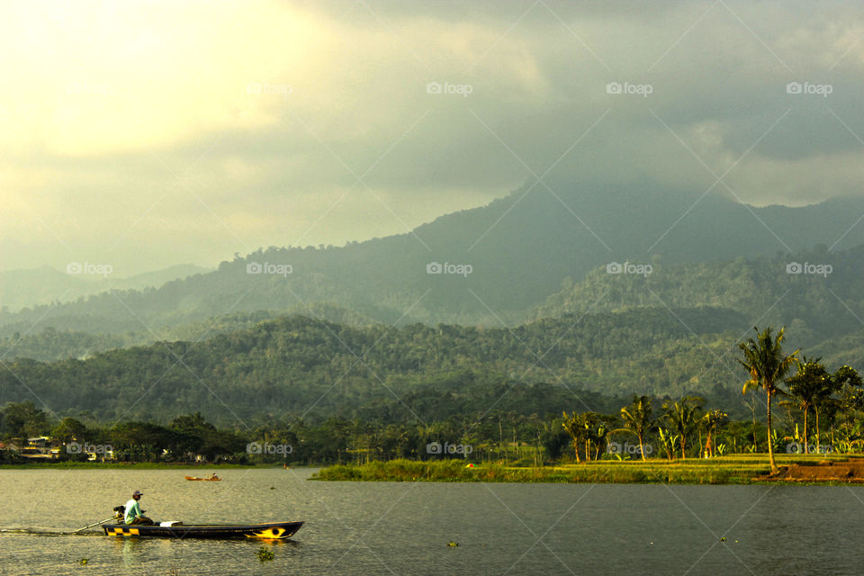 Mountain and lake with man on boat