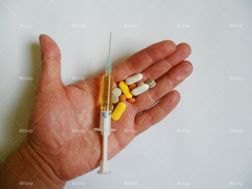 medical syringe, tablets and pills are on a white background