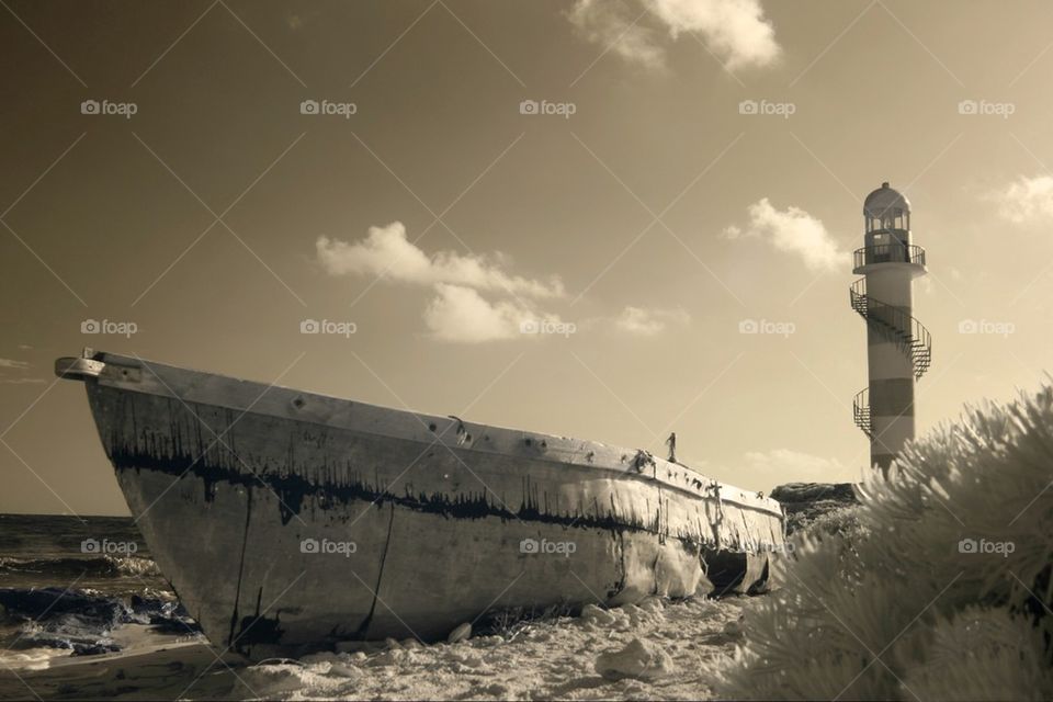 Old abandoned boat by the lighthouse