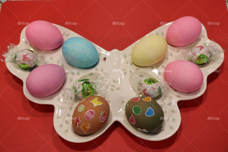 Easter eggs and chocolates in butterfly shaped plate