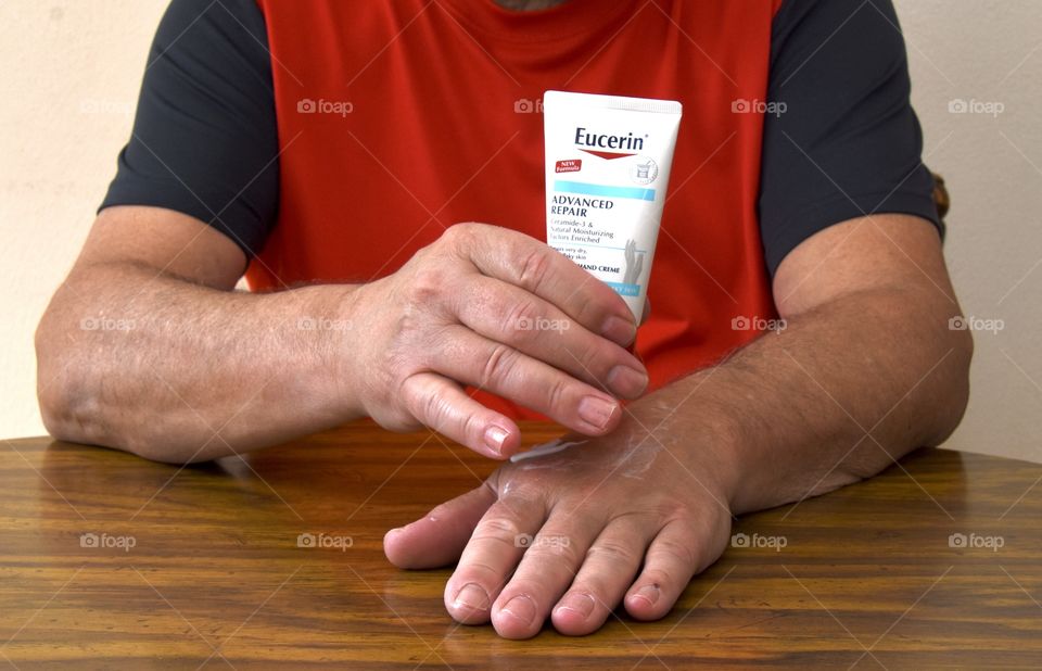 Eucerin lotion being applied to a man’s hands