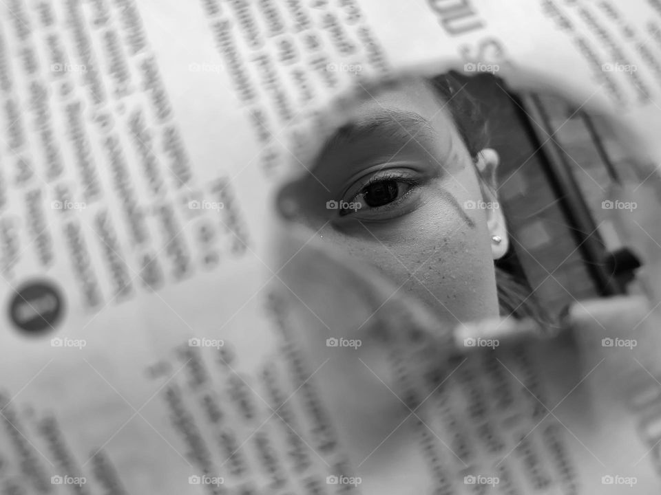 Girl looking through newspaper