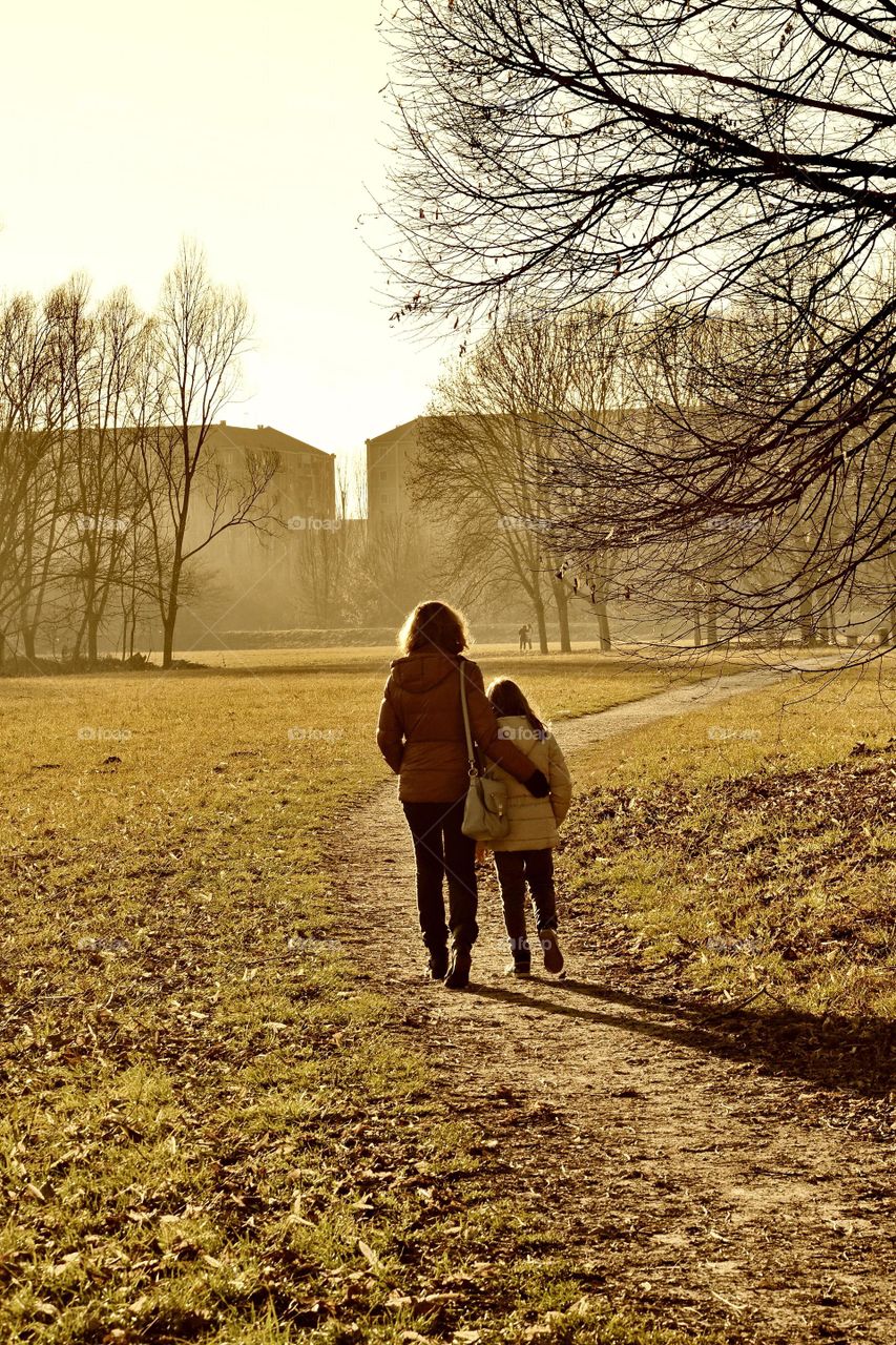 Mother and daughter walking embraced