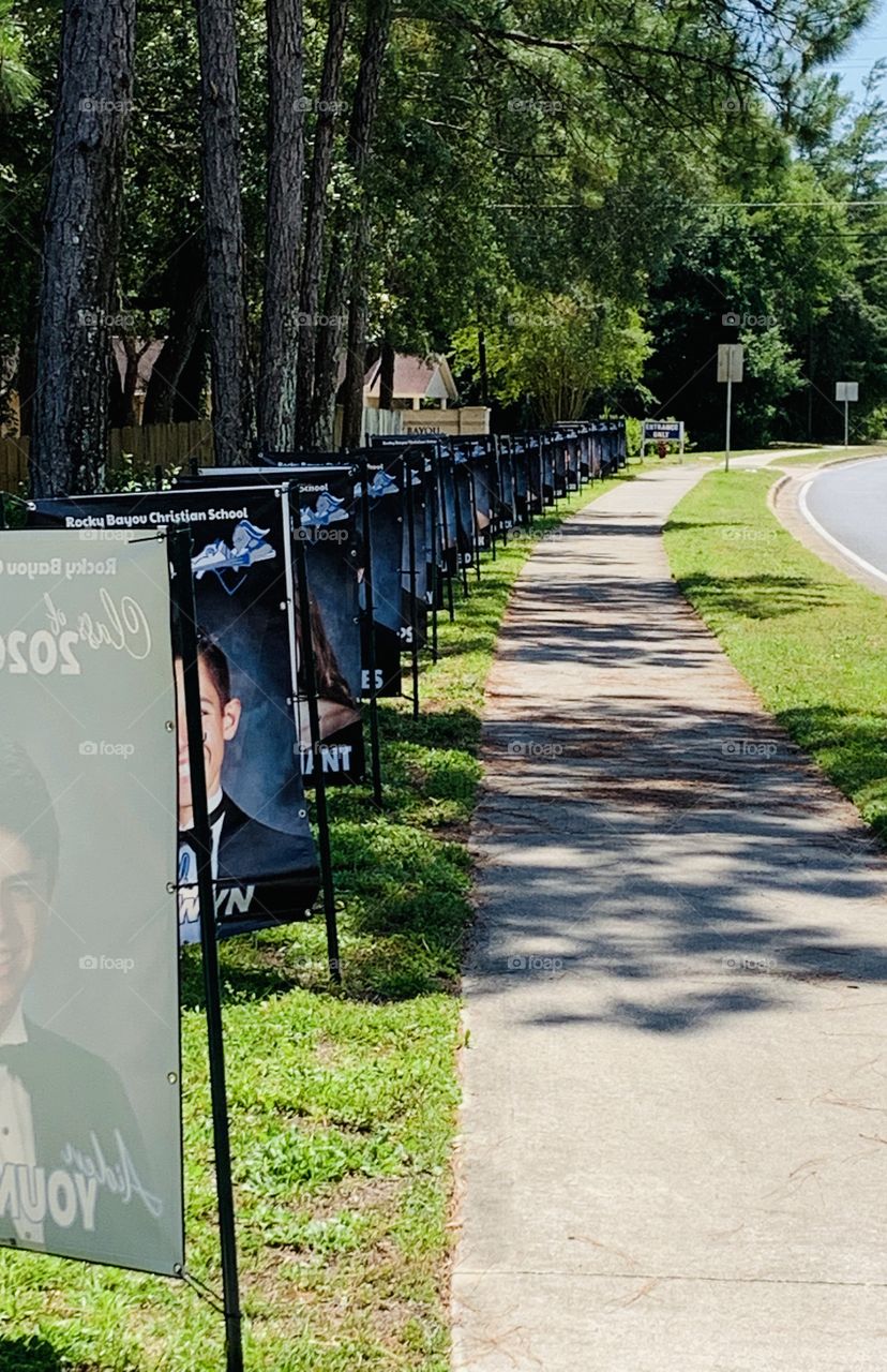 CORONAVIRUS 2020 Graduation Ceremony - Graduates photo posters line the front of the school grounds expressing a big congratulations. A soleum event for the 2020 graduating students. 