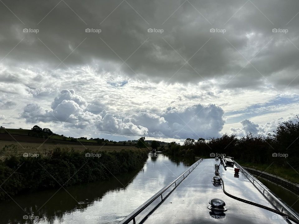 Afternoon sky clouds narrowboat cruise on Oxford canal reflection nature weather vacation historic waterway England holiday late summer