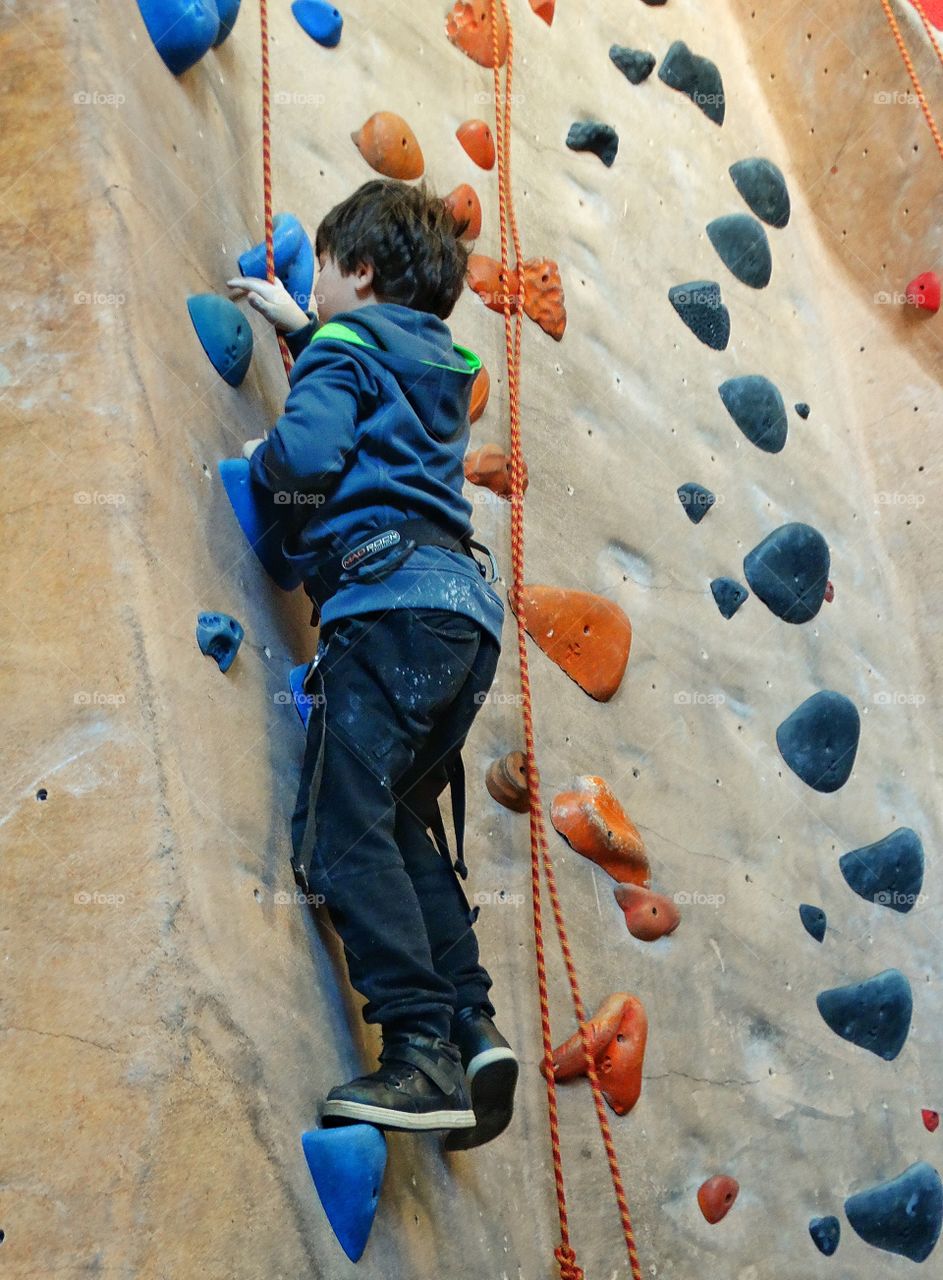 Boy Climbing A Rock Wall
