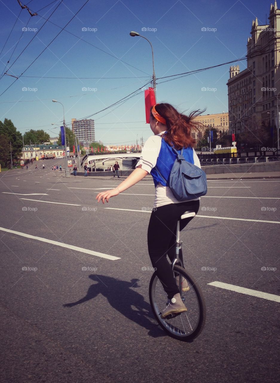 Girl riding unicycle bike on one of the streets of Moscow, Russia