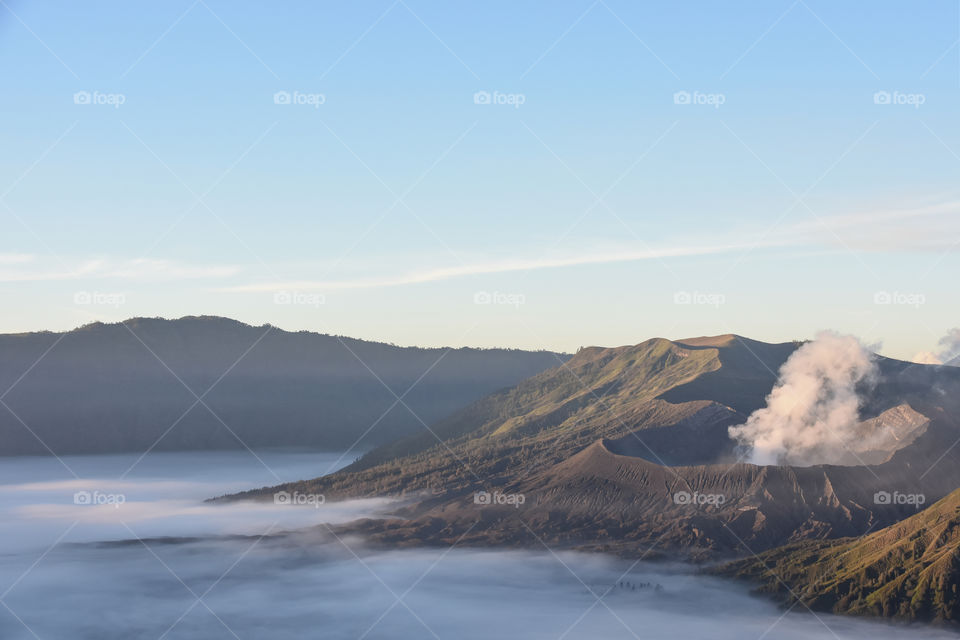 A steaming crater of Bromo active volcano during sunrise