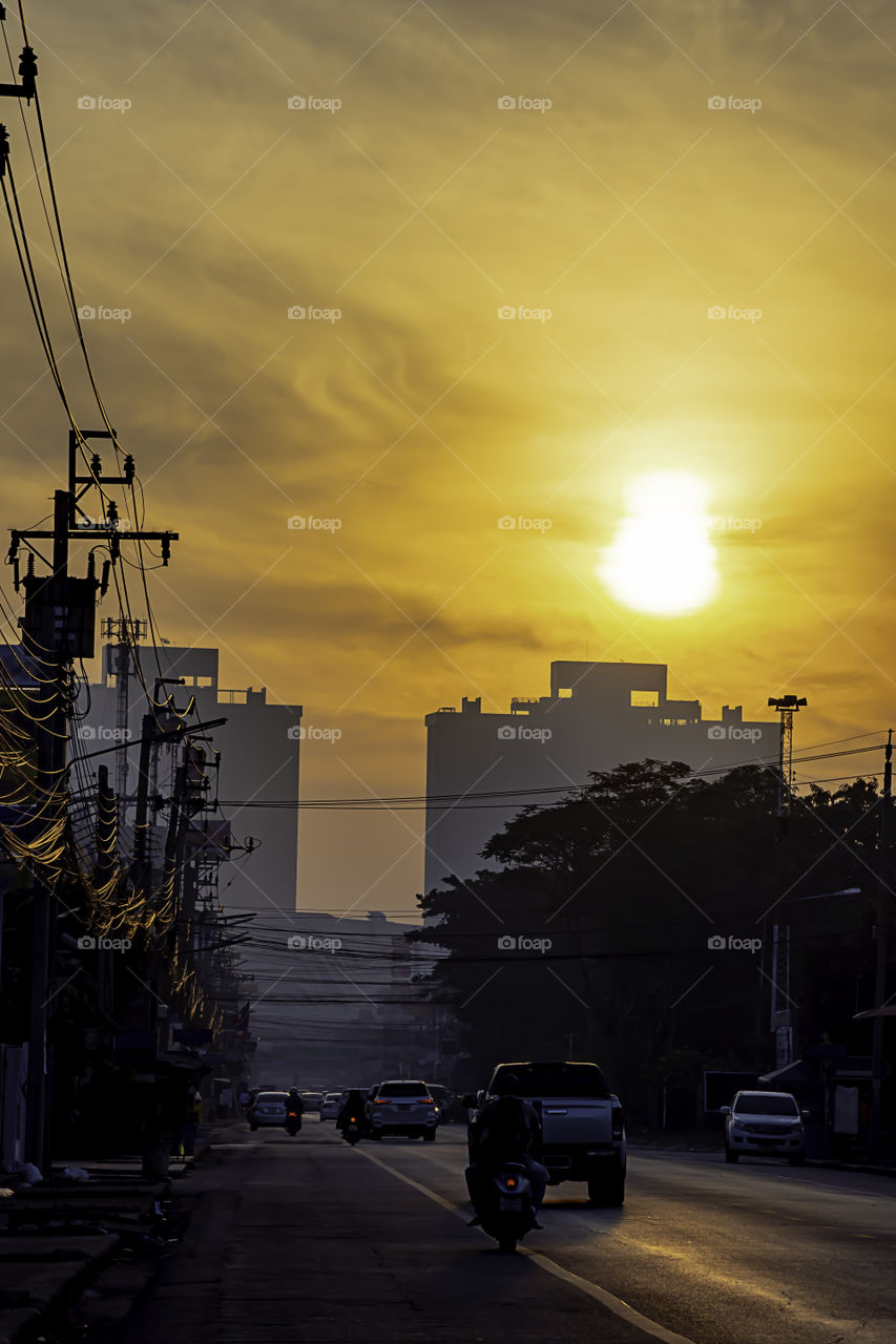 The early morning sunlight shining on buildings and the cars on the road at Bangyai City of Nonthaburi in Thailand.