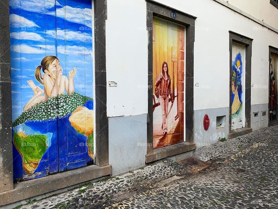 A collection of colorful and vibrant painted door ways along the cobblestone streets of Funchal Madeira 