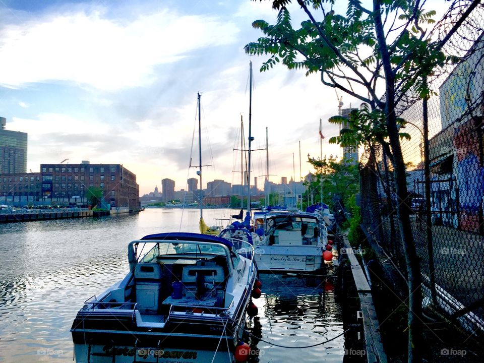 A beautiful scene in Newtown Creek of LIC, Queens, NY right after sunset at twilight time. Sailboats and motorboats are in the foreground whereas in the far distance Manhattan and parts of Queens can be seen. 2018 Hypnotic Productions
