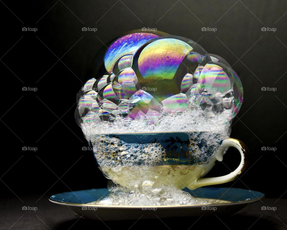 Still life of bubbles overflowing a tea cup 