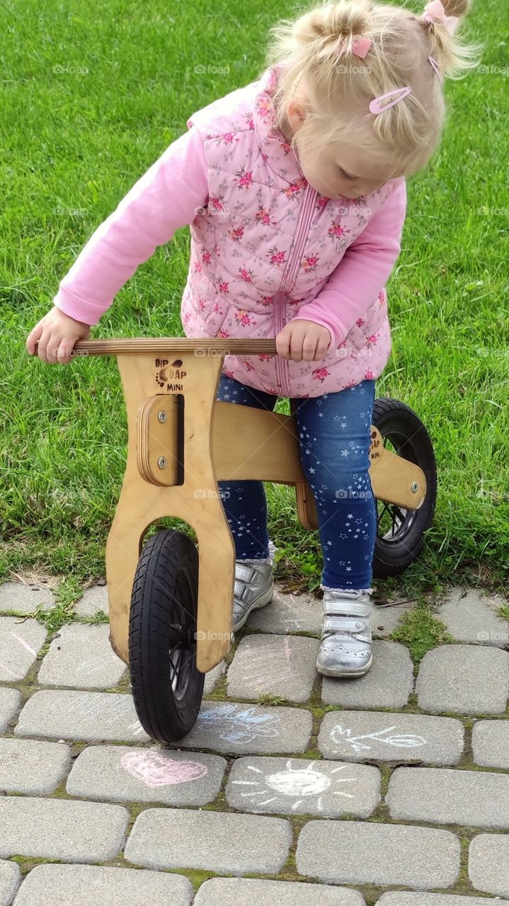 Kid on bike and art with crayons on street