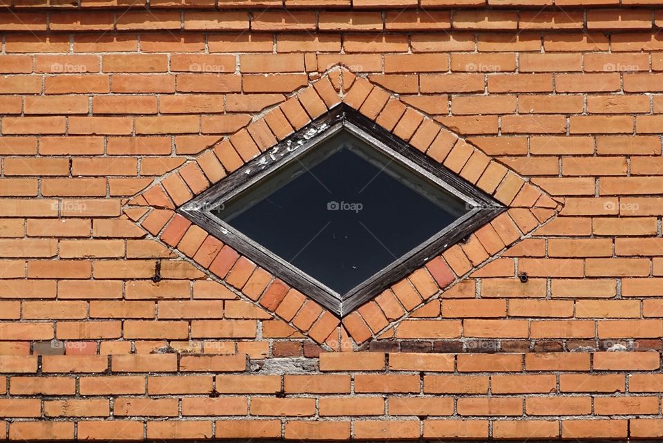 Diamond shaped window in light brown brick