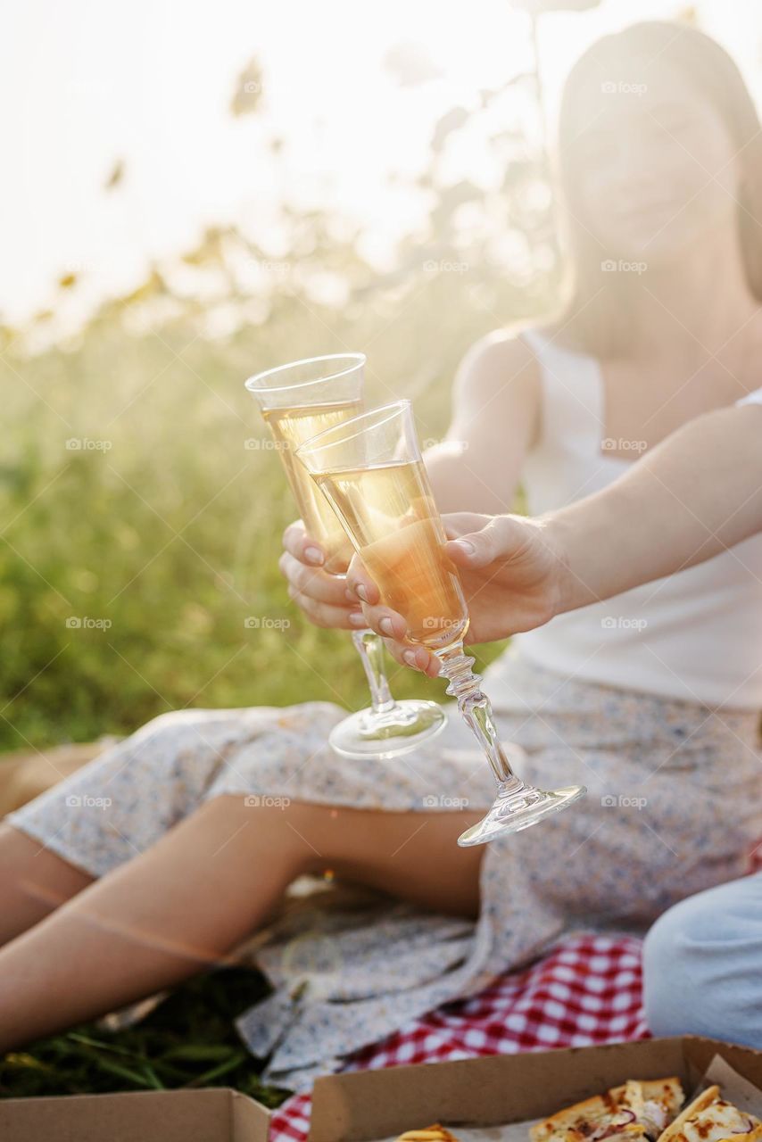 couple drink champagne outdoors on picnic