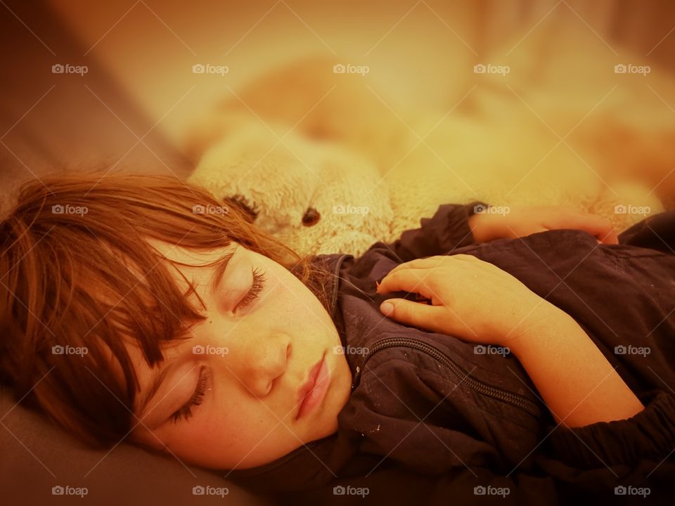 Little girl falls asleep and dreams peacefully next to her teddy