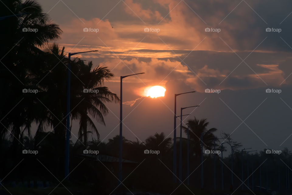Setting sun. Sunset Sundown. Evening sky. Disappearance of Sun below west horizon. Beautiful atmospheric refraction illuminates sunlight rays and astronomical twilight. Darkest moment before night.