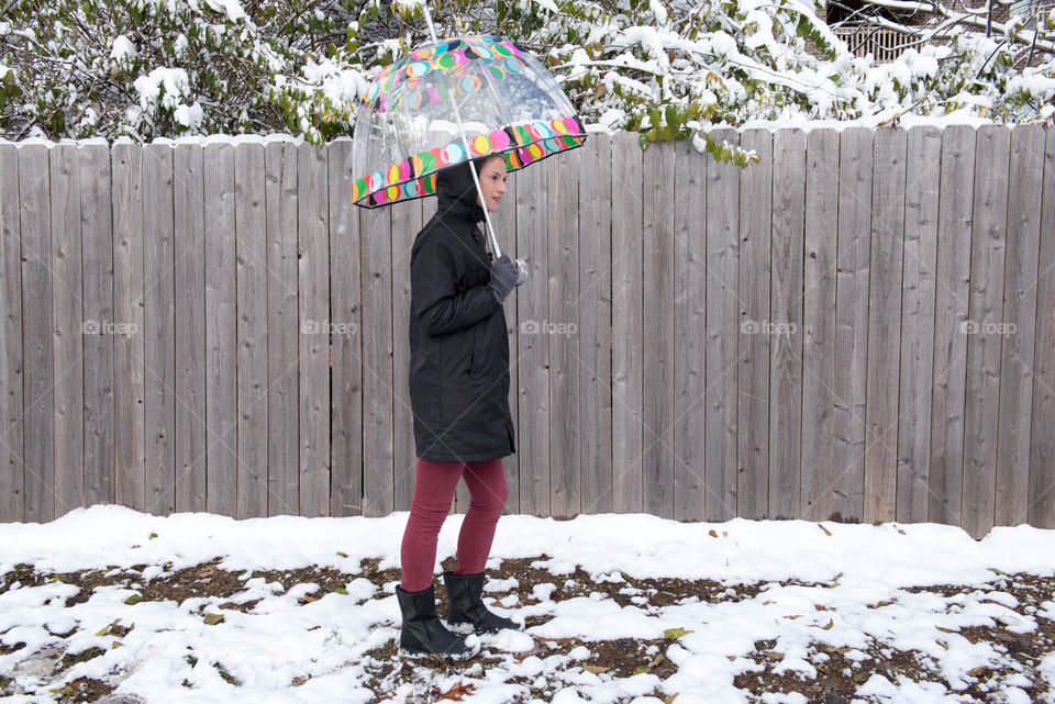 Young woman holding an umbrella in the snow outdoors
