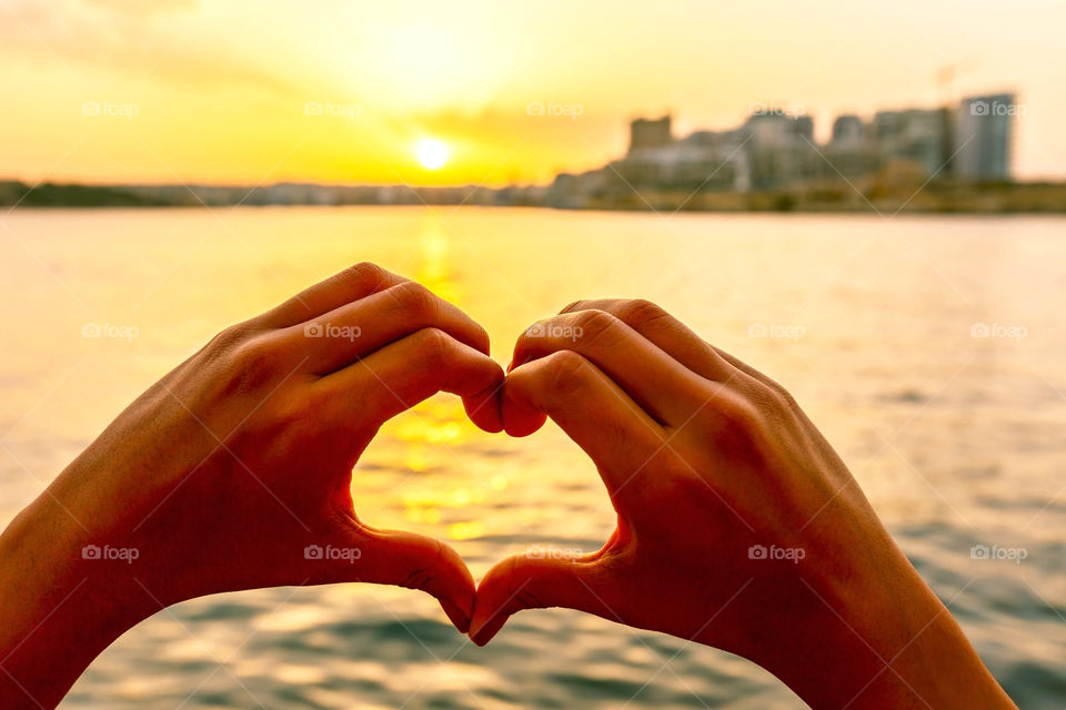 Close-up of a person's hand making heart shape