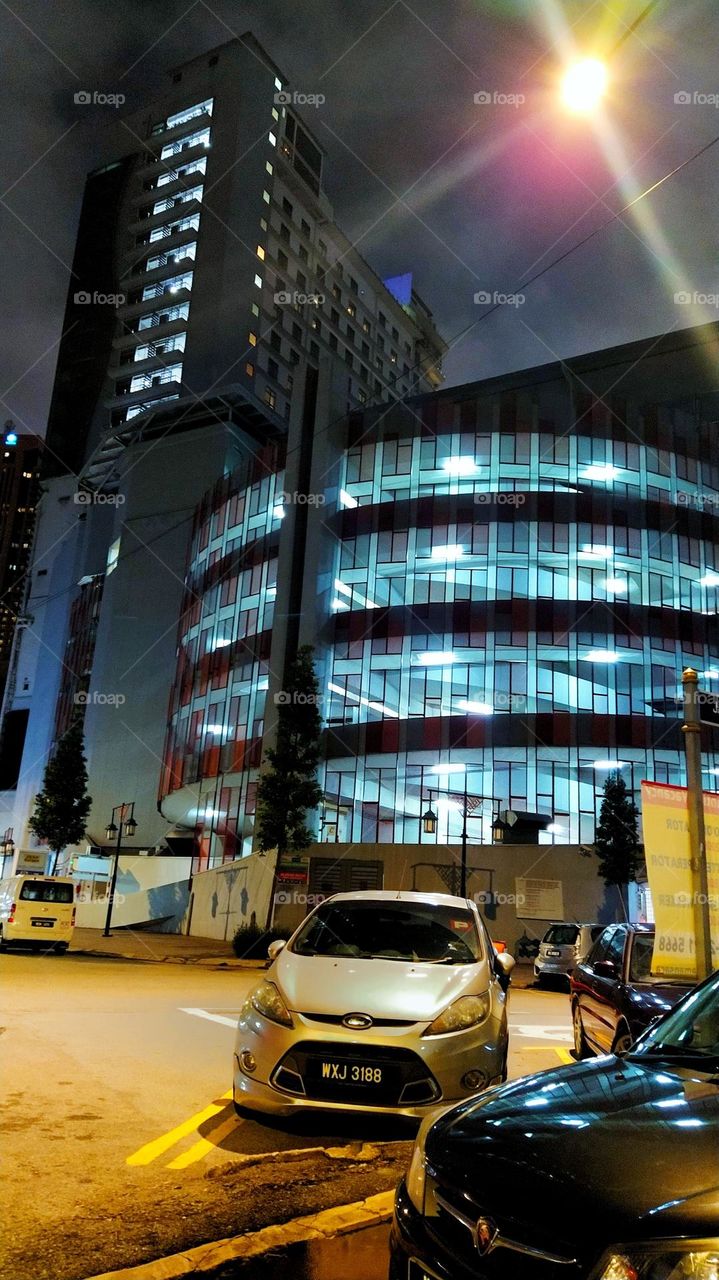 Modern ordinary cars in the street of Kuala Lumpur Malaysia at night