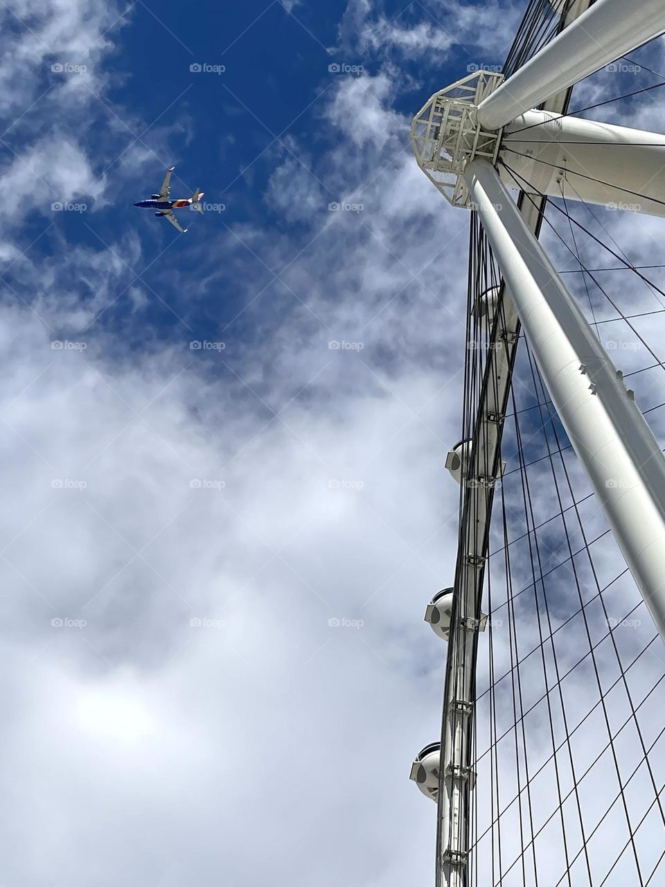 Airplane flying next to the ferry wheel 