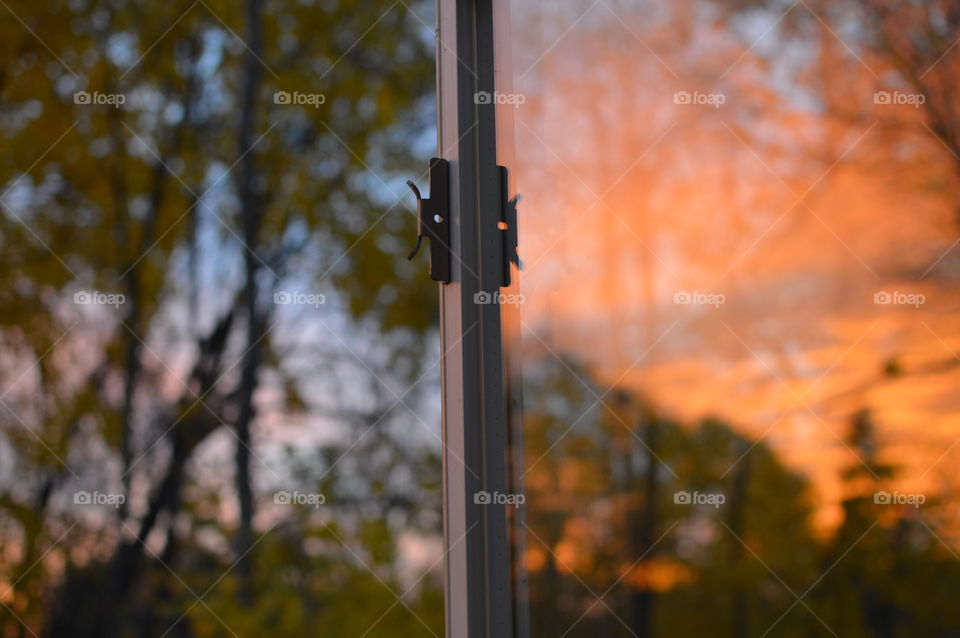 Open window with reflection of sunset in the glass