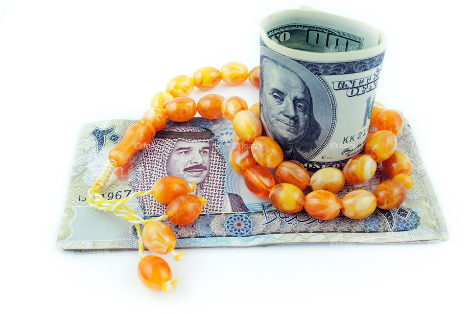 USA and Bahrain currency with rosary isolated background
