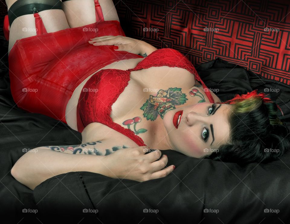 Sexy woman lying on bed in red bikini