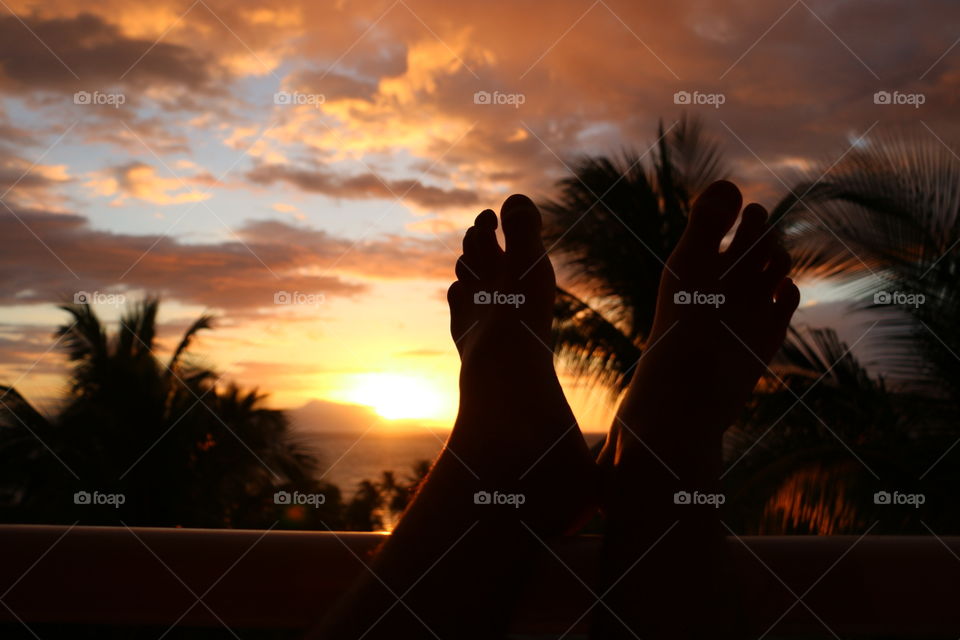 Feet against sunset