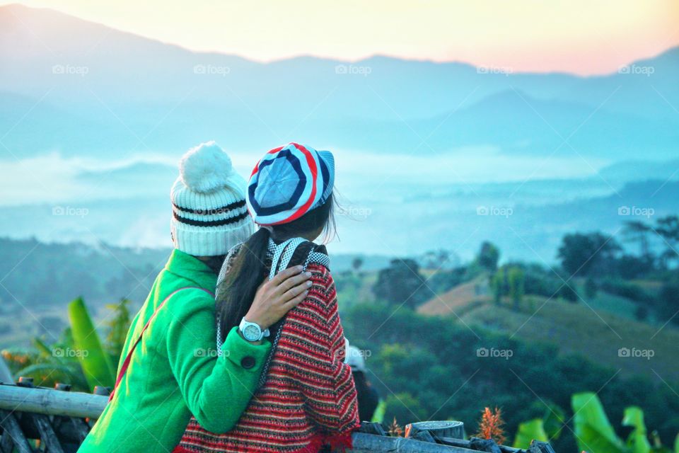 2 tourists are standing in the morning viewpoint To experience the cold weather and watch the morning mist At Yun Lai Viewpoint, Pai District, Mae Hong Son Province, Thailand. This is one of the most popular tourist attractions.