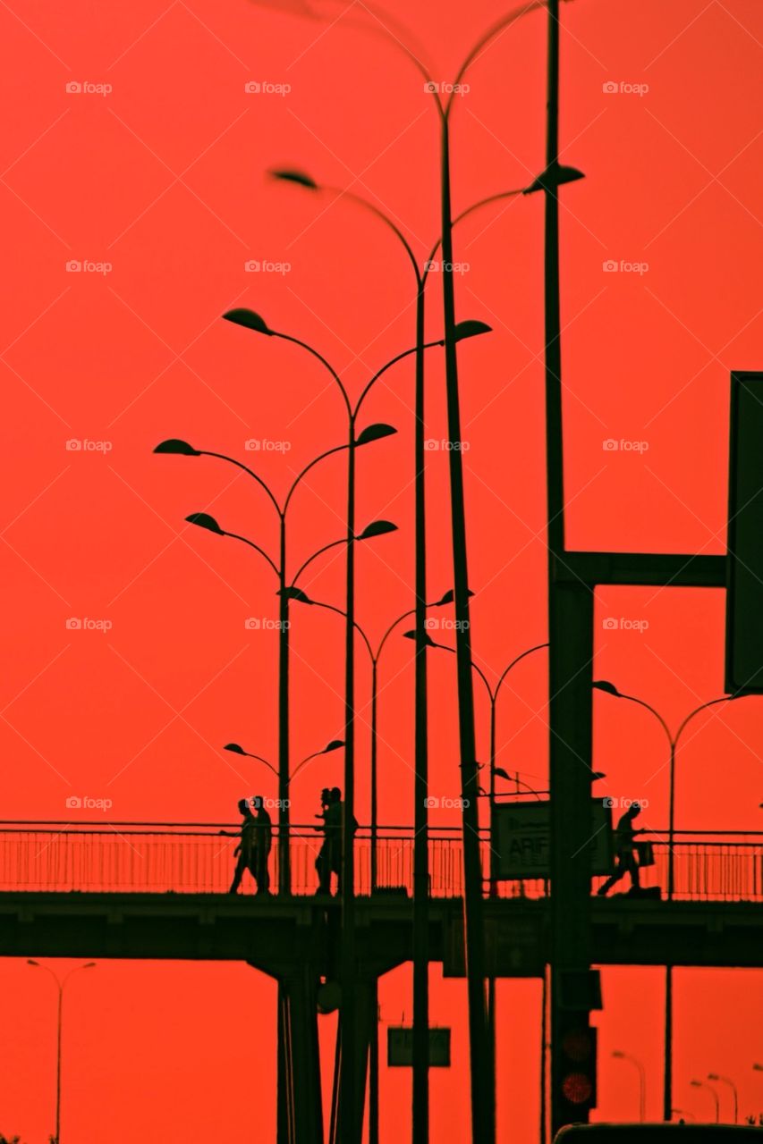 Silhouette of people walking on bridge