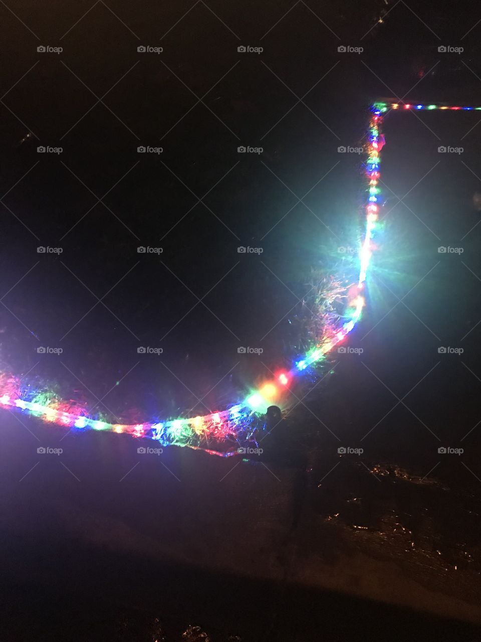 Row of brightly colored Christmas lights glowing at night on a cool winters night in December. USA, America 