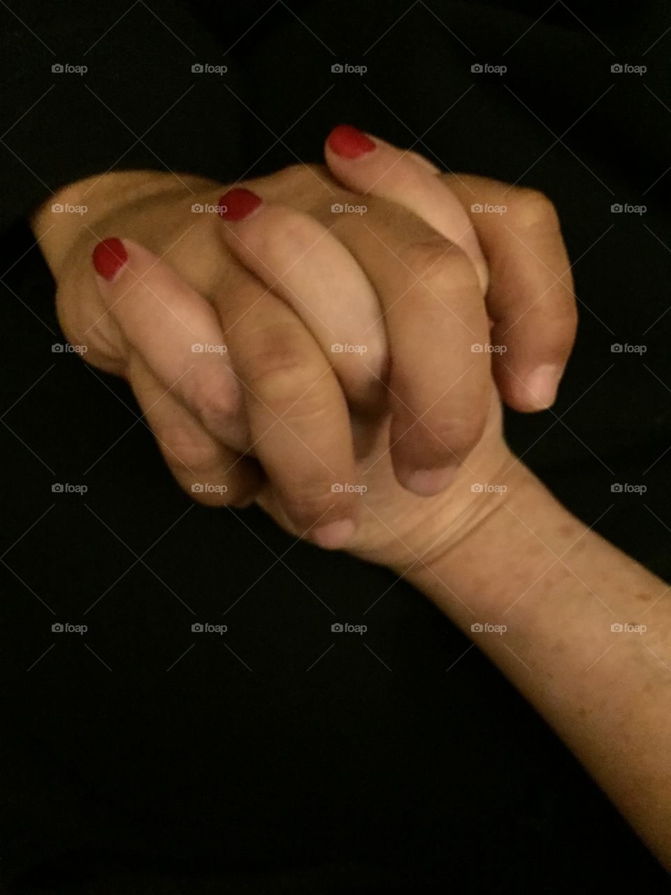 Holding hands against black background