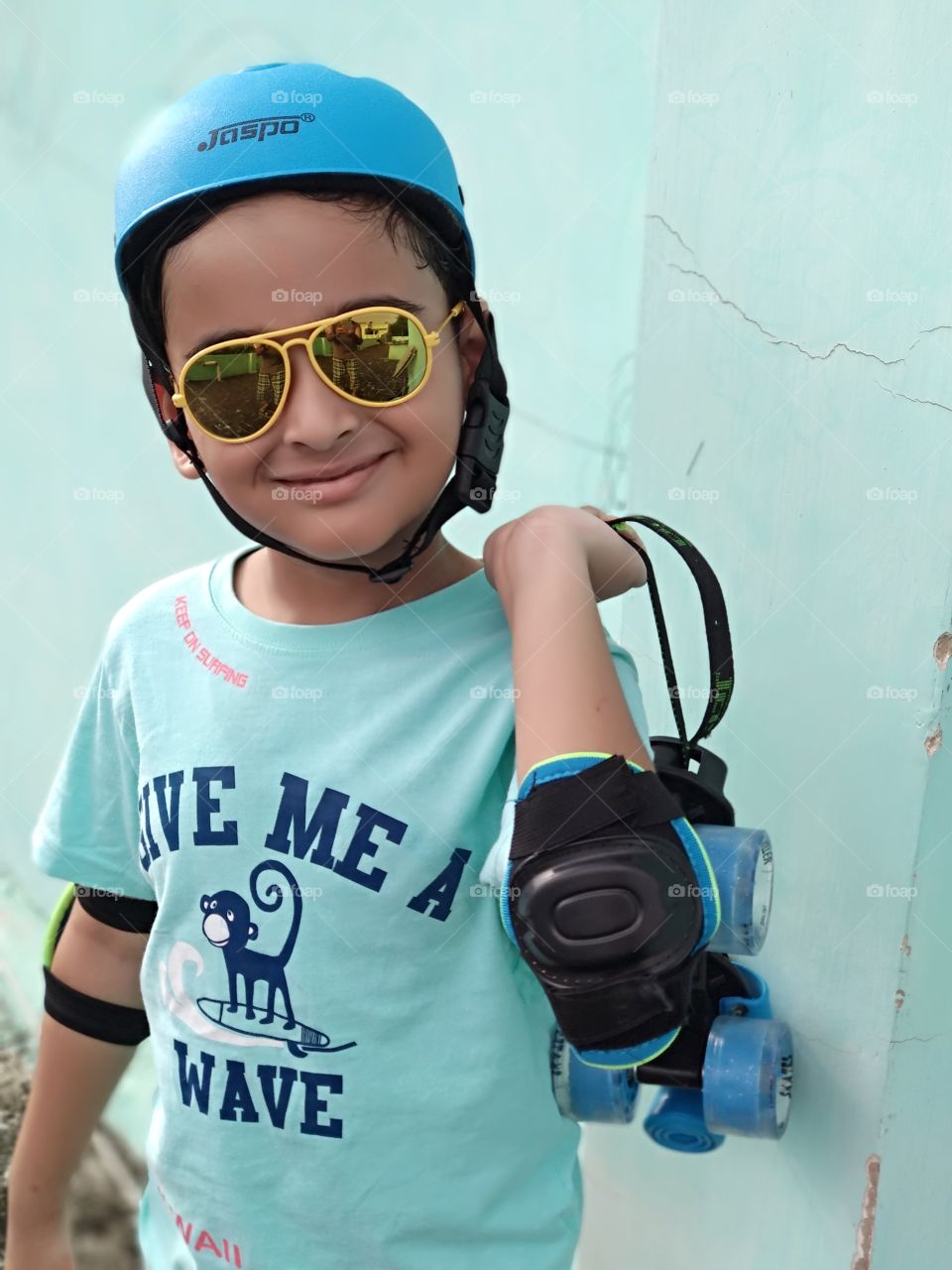 Smiling Indian kid with skates wearing helmet
