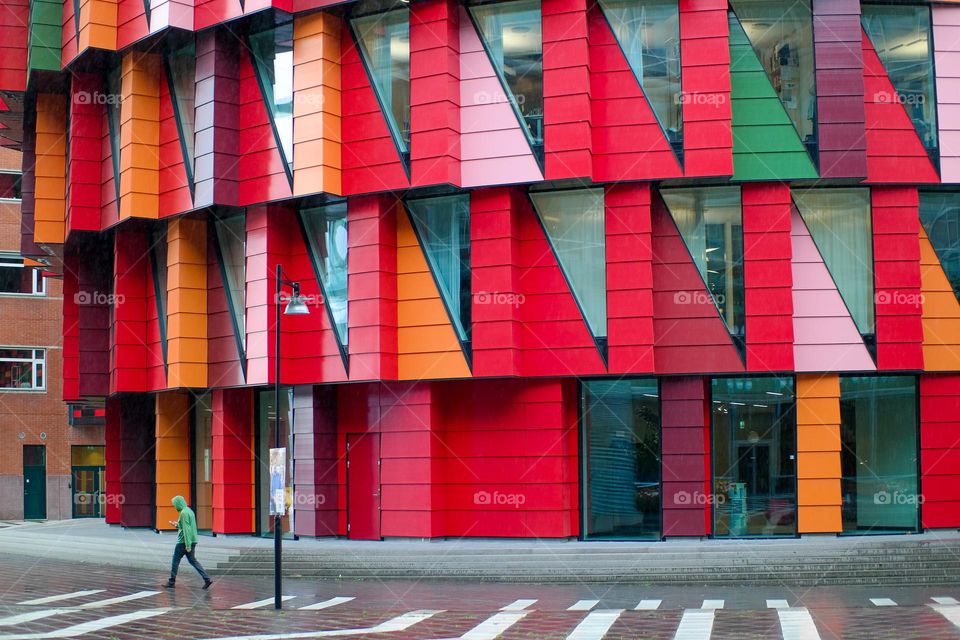 Person walking in front of colourful modern building