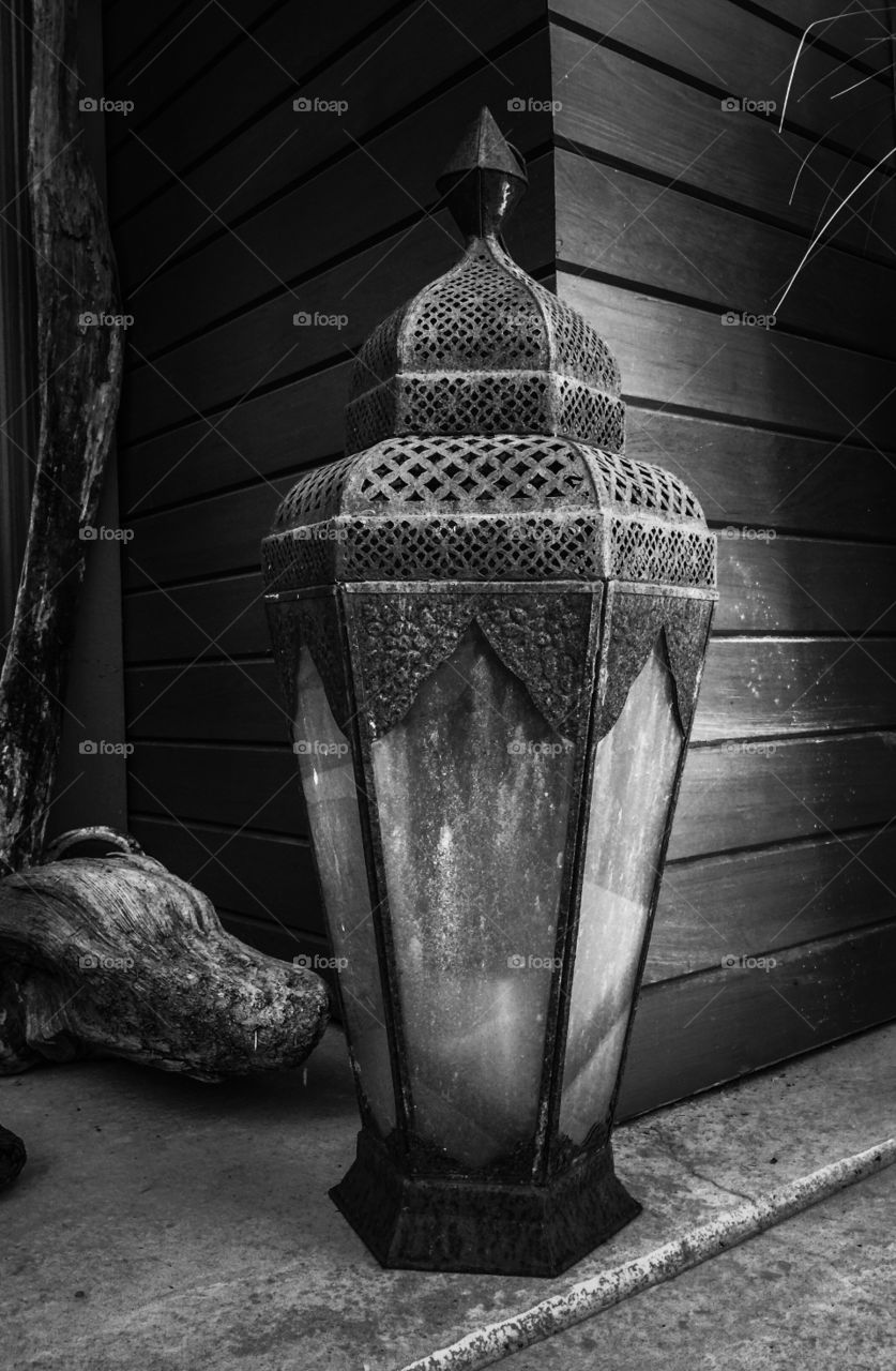 Antique lamp on display on the front porch In black and white 
