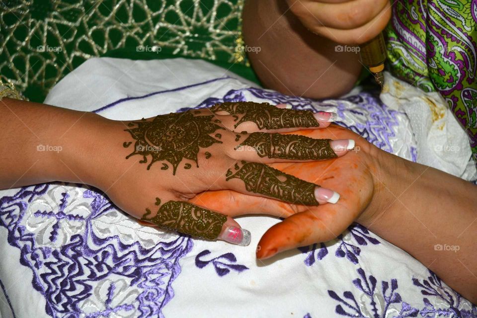 hand is painted with henna before the wedding