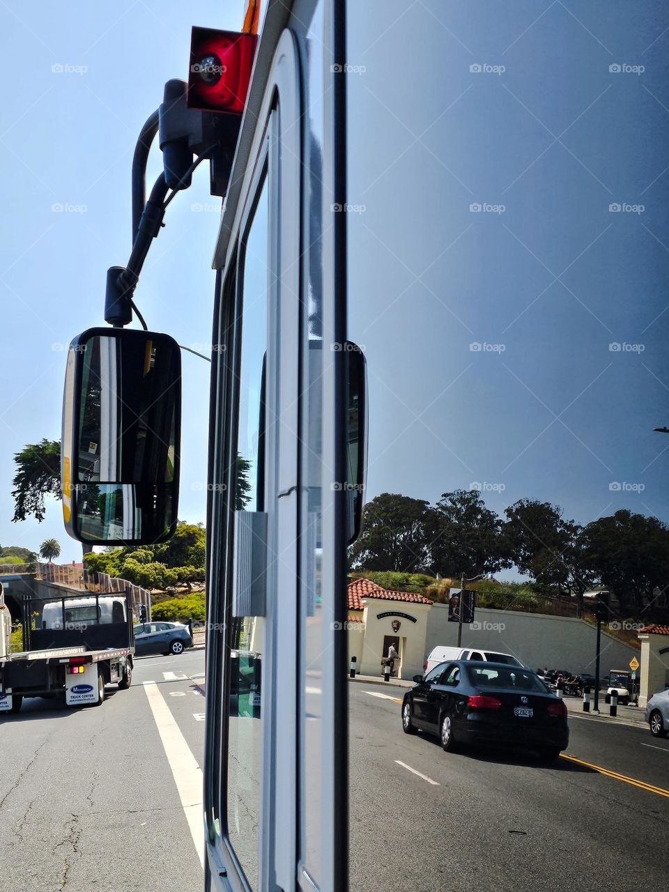 Reflection in the windows and mirror of a Public transportation bus on the city streets of San Francisco California 