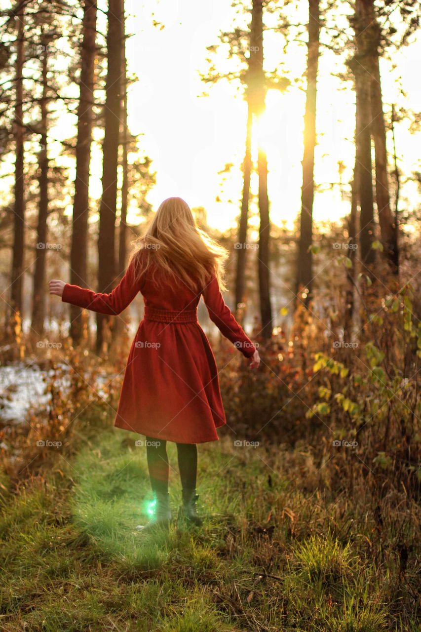 Girl in a red coat in the autumn forest