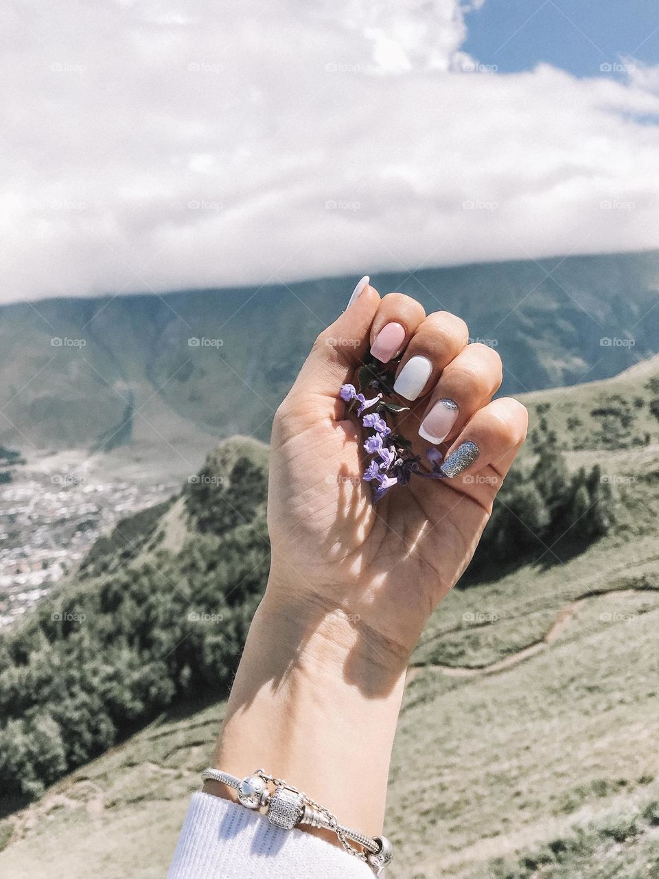 Woman manicure against natural mountain background. Female beautiful nails. 