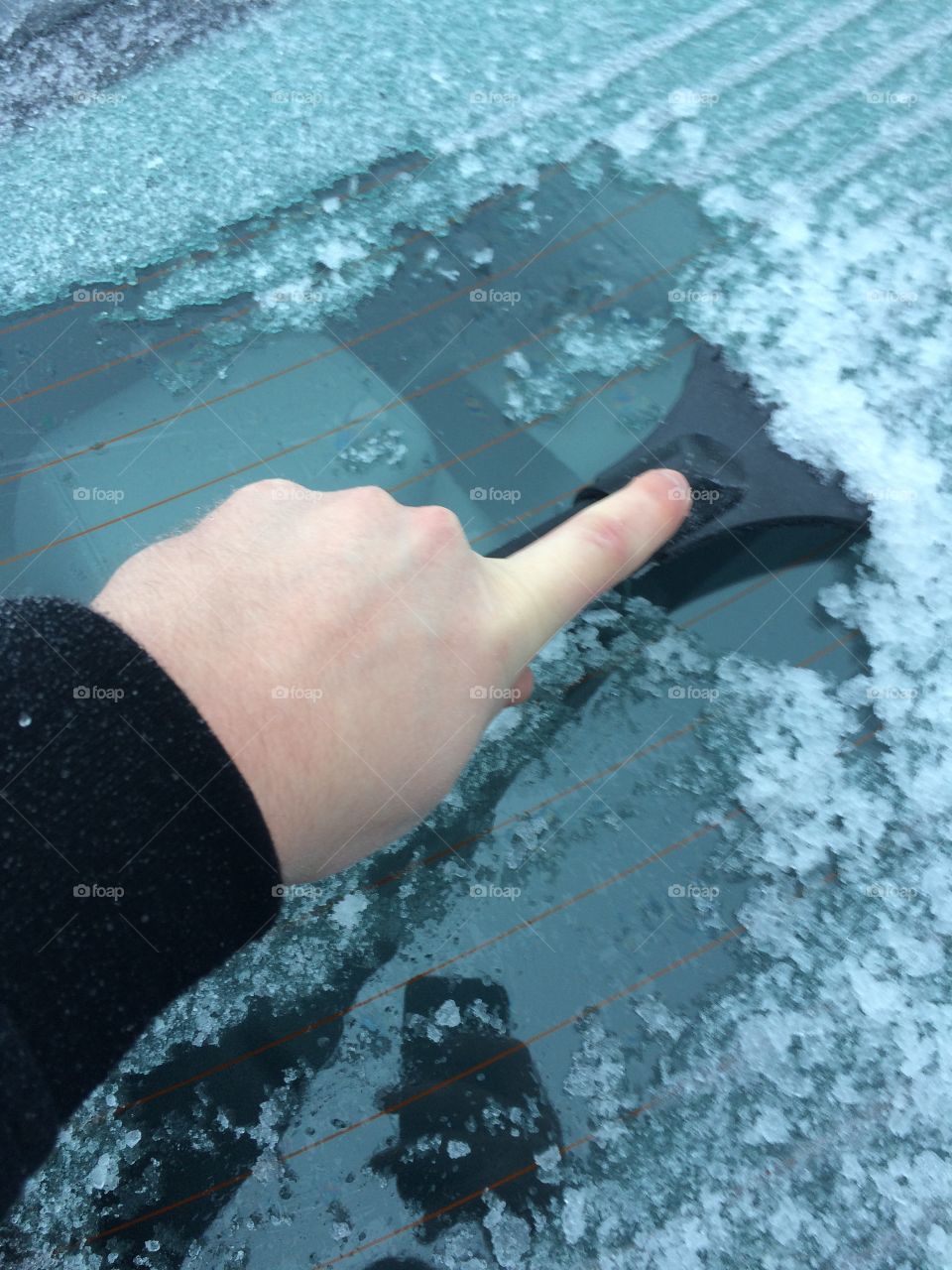 Scrapping ice from the rear window. 
