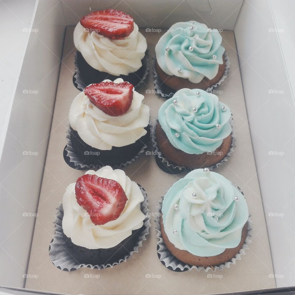 cupcakes with white and blue cream cheese
with strawberries and silver pearls