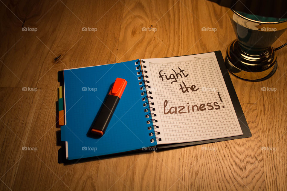 Motivational letter in a notebook on the desktop under the light of a lamp