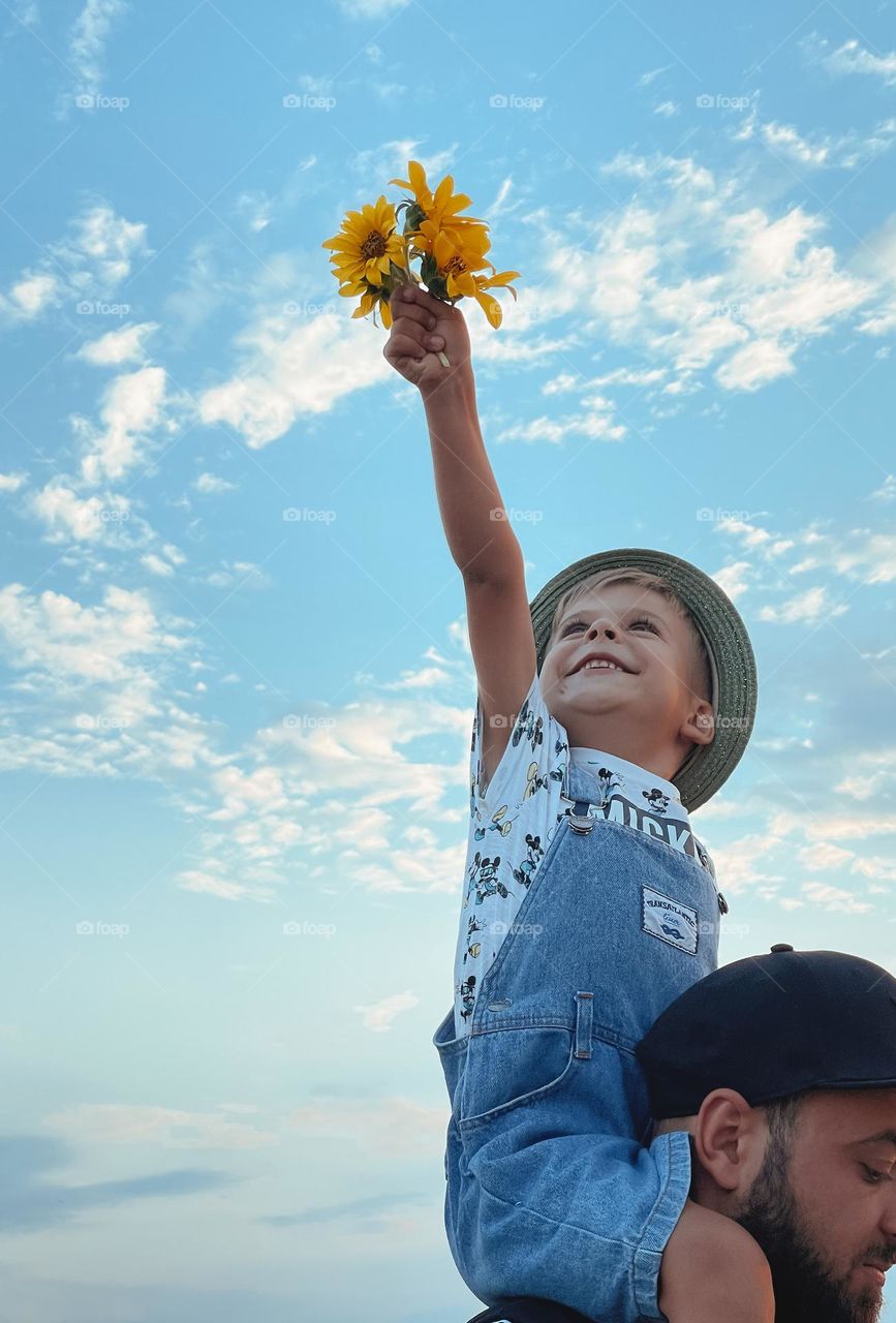 Smiling boy with yellow sunflowers