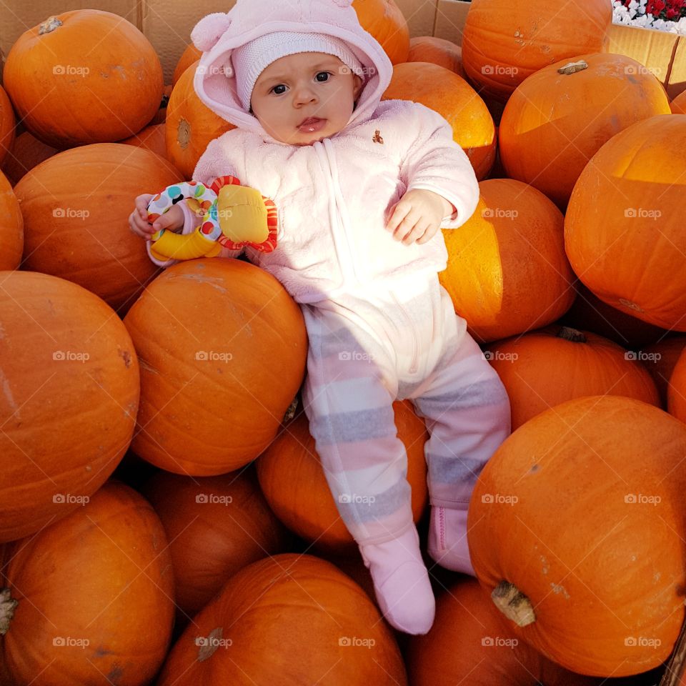 Baby with pumpkins.