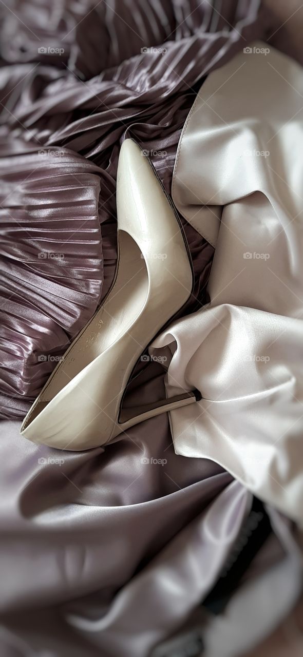 женская туфля на фоне атласных тканей