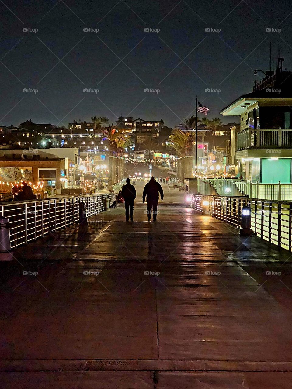 Hermosa Beach pier on a January night is cold and deserted with very few people out walking