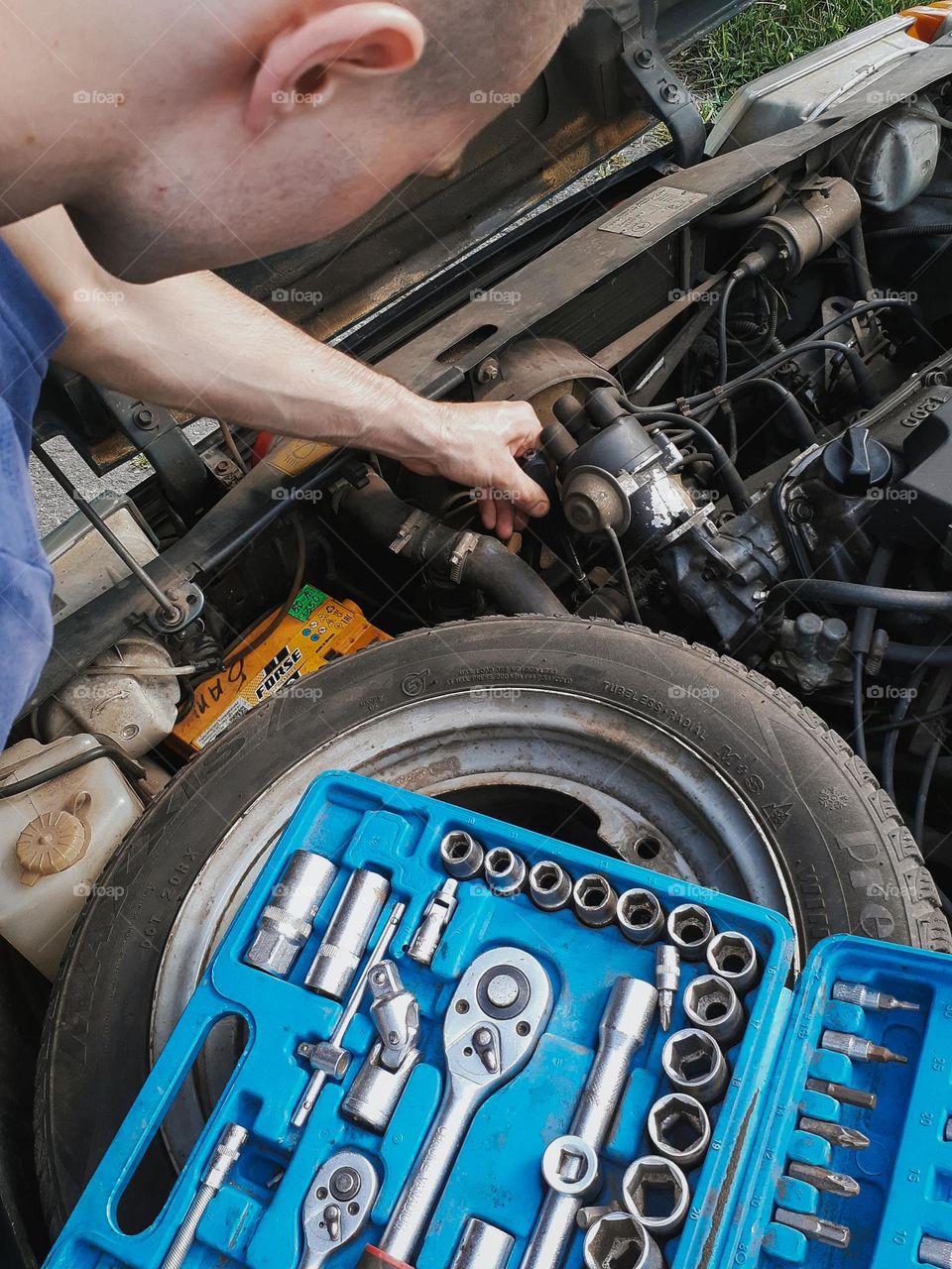 The mechanic conducts diagnostics under the hood of the old Slavuta