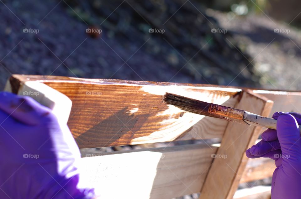 Applying wood stain to a homemade wine rack.