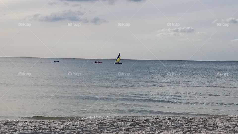 distant ships look on the horizon, padding kayak along the Gulf of Mexico off the beaches in naples, fl